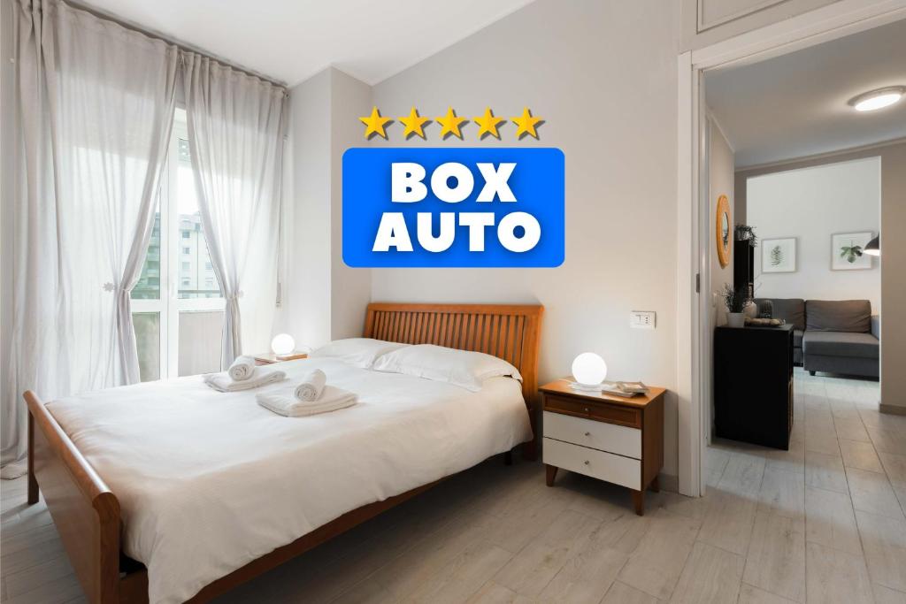 1 dormitorio con 1 cama con un cartel de caja en la pared en The Green House - Private Parking and Balcony en Milán