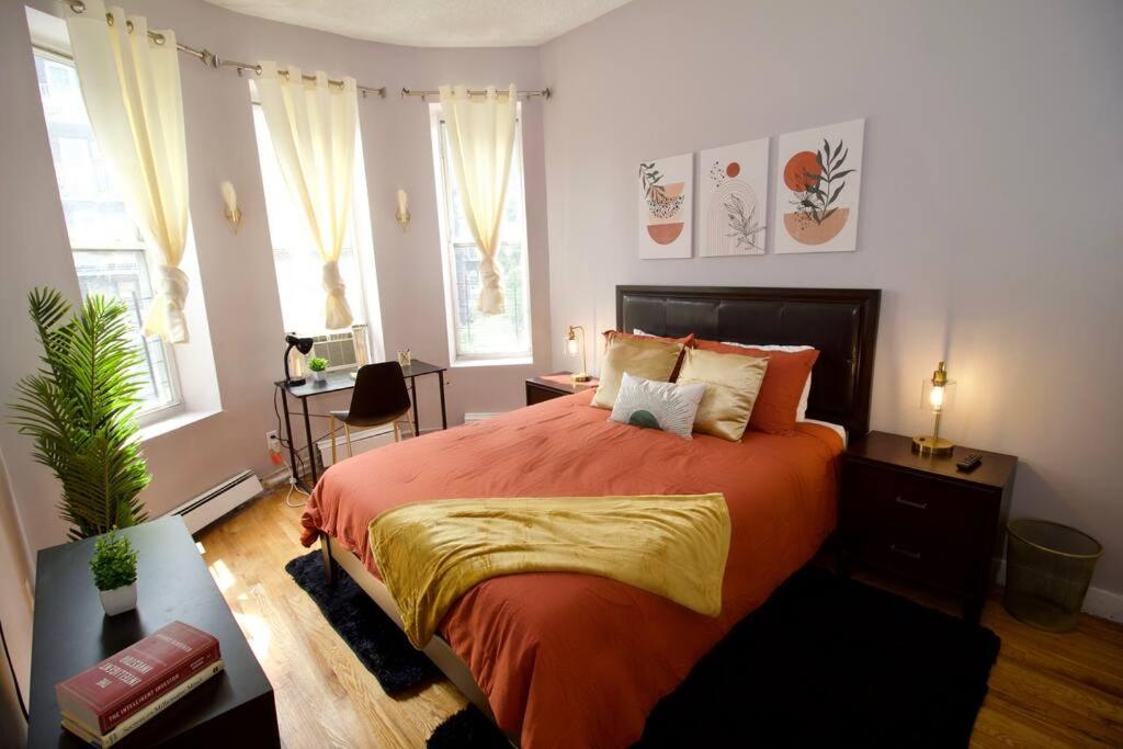 - une chambre avec un grand lit orange et des fenêtres dans l'établissement Tuk Ahoy - Sunset Suite 2B with Shared Spaces, à Brooklyn