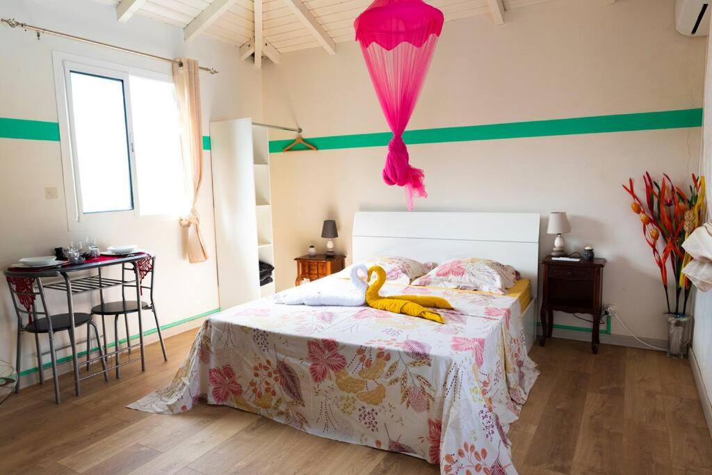 sypialnia z łóżkiem z wypchaną kaczką w obiekcie Studio Soleil Couchant w mieście Pointe-Noire