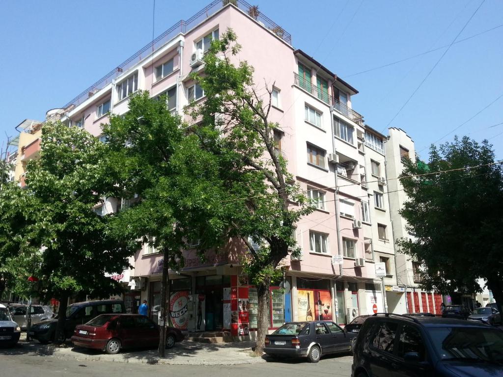 un edificio blanco alto con coches estacionados frente a él en Studio Zora en Burgas