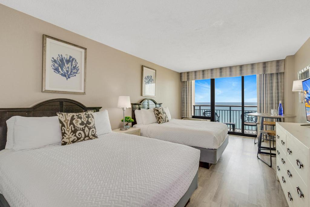 a hotel room with two beds and a balcony at Oceanview Studio Escape With Beach Steps Away! 1828 in Myrtle Beach