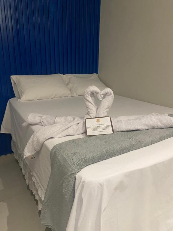 a bed with towels on it with a plaque on it at Origem in Mamanguape