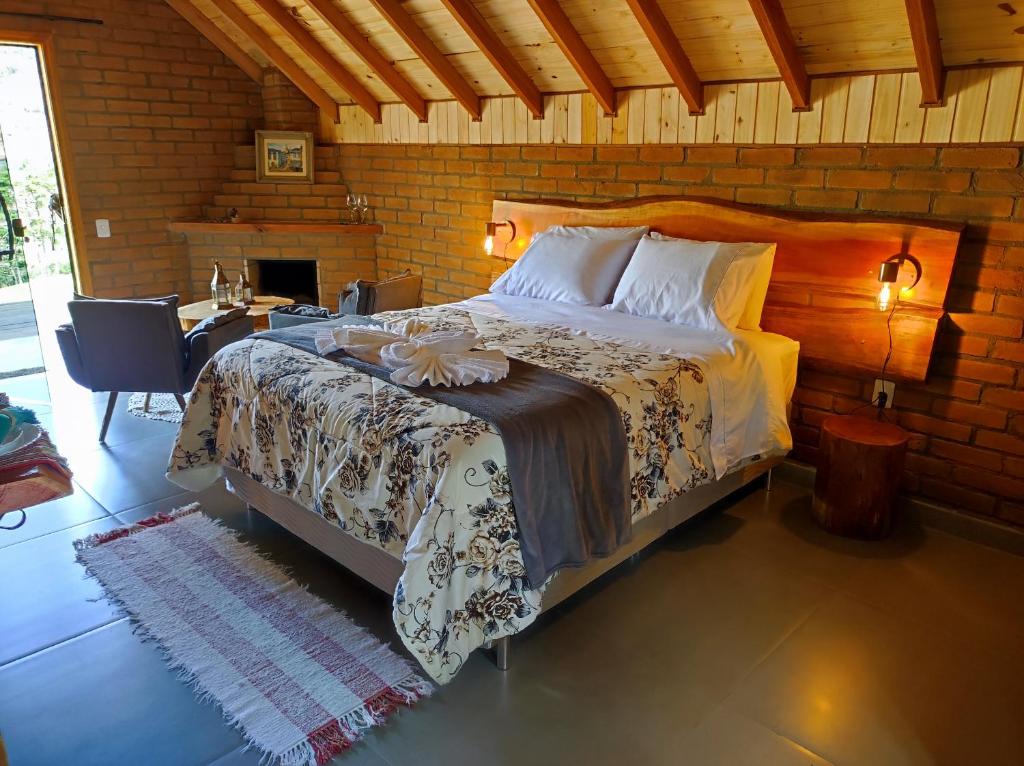 een slaapkamer met een bed en een bureau in een kamer bij Pousada das Castanheiras in Monte Verde