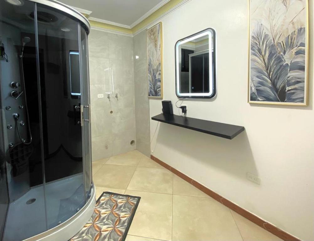 a bathroom with a shower and a sink and a mirror at HABITACION CON BAÑO COMPARTIDO in Guayaquil