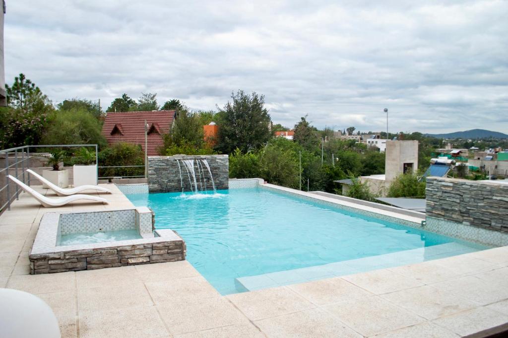 a large swimming pool with a water fountain at Sierras Apartamentos in Villa Santa Cruz del Lago