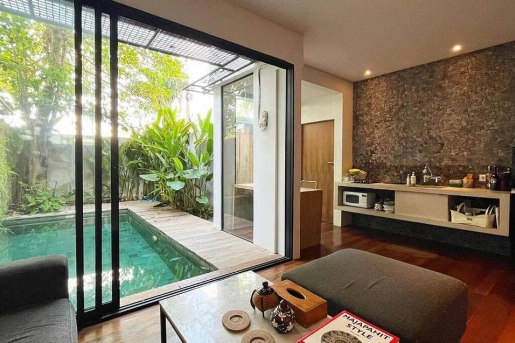 uma sala de estar com uma piscina e uma cozinha em Zenith villa Pererenan em Munggu