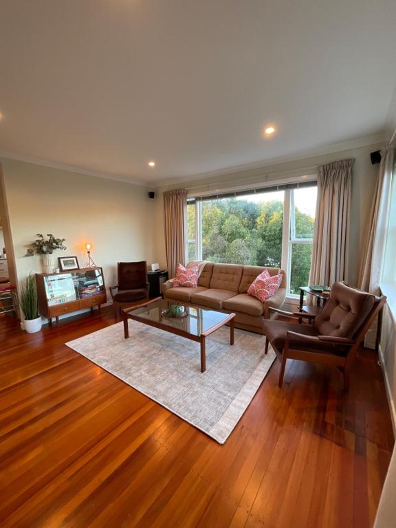 uma sala de estar com um sofá e uma mesa em Refined, Retro & Relaxing em Paraparaumu