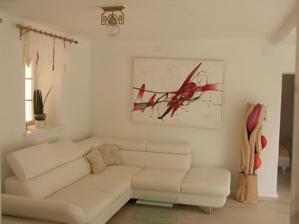 una sala de estar blanca con un sofá blanco y una pintura en Schneiders Ferienhaus Pulkau, en Pulkau