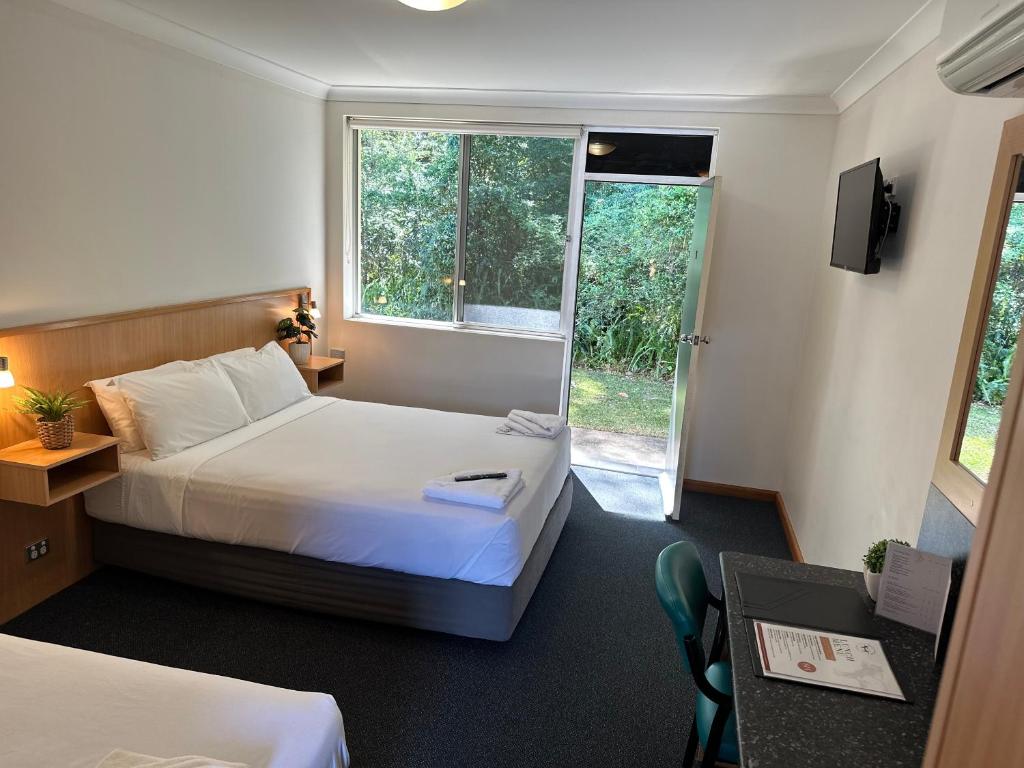 um quarto de hotel com duas camas e uma janela em Bull and Bush Hotel em Medowie