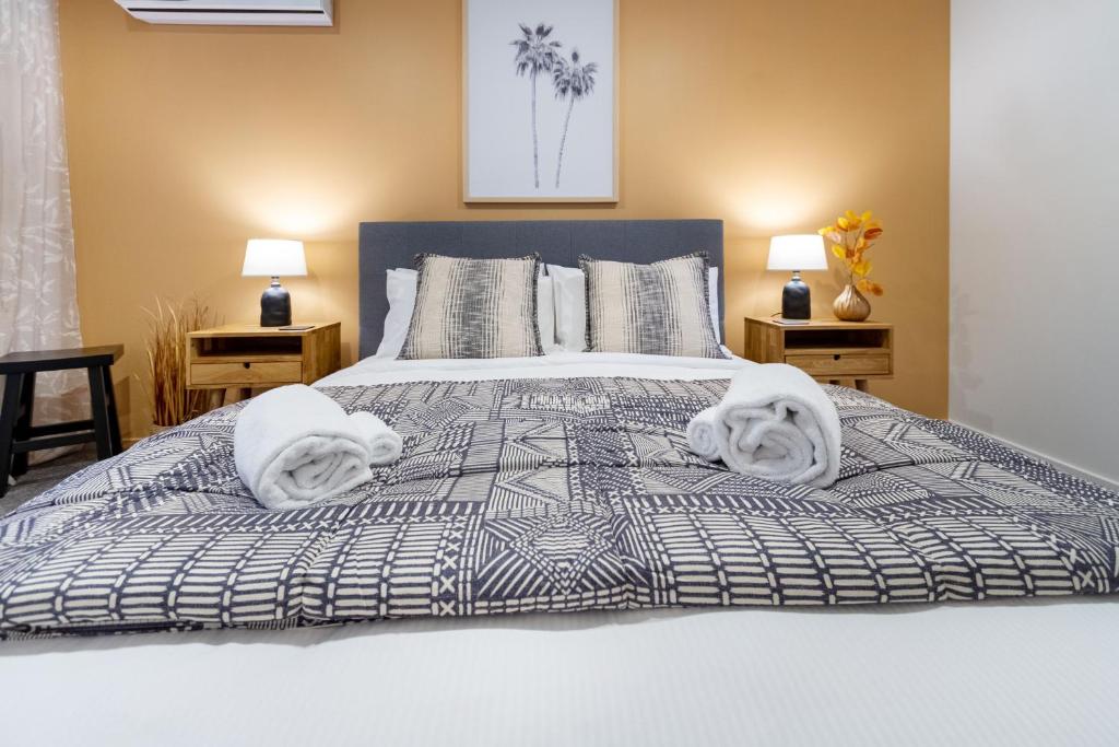 a bedroom with a bed with towels on it at Central Charm 2 bed 2 bath w/ sunny Balcony in Christchurch