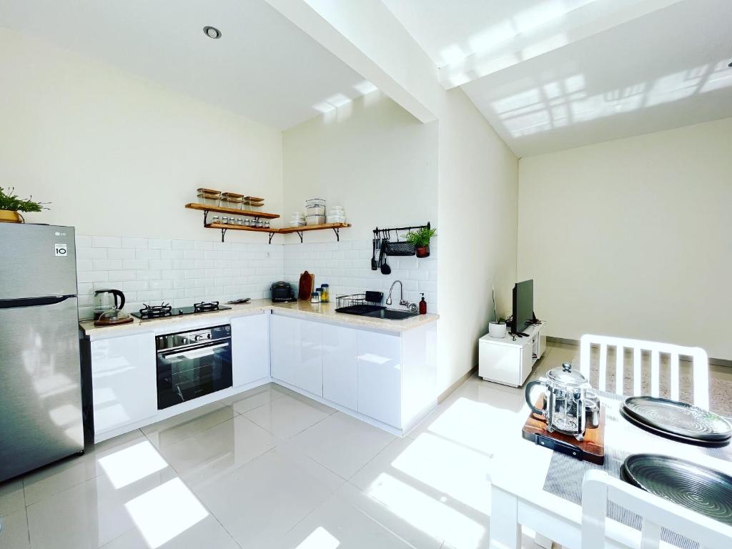 a kitchen with white cabinets and a stainless steel refrigerator at Villa LA Mansion Lembang in Lembang