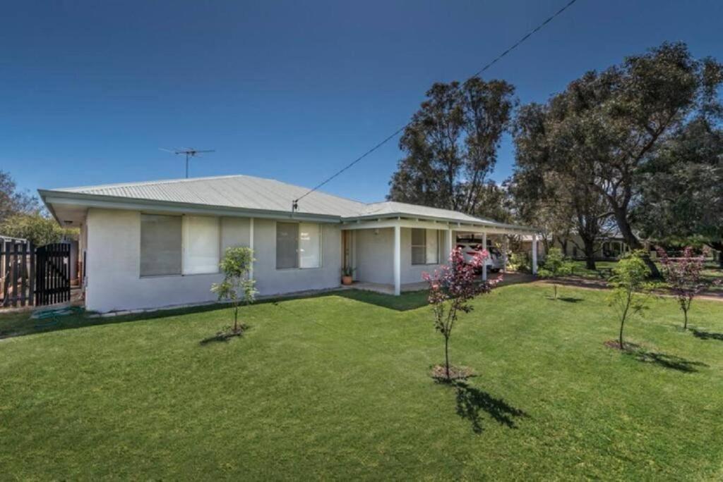 a white house with trees in the yard at Lake Edge Retreat in Quindalup