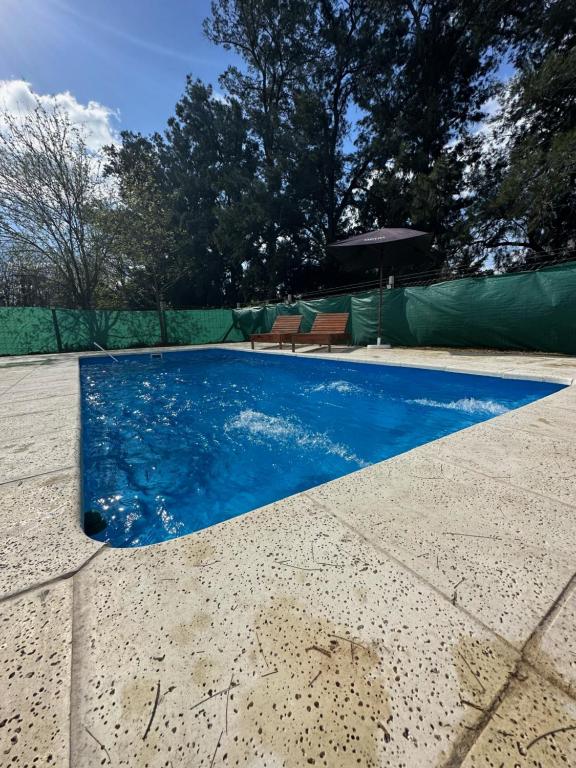 una piscina de agua azul en un patio en Casa Quinta La Tranquera en La Reja