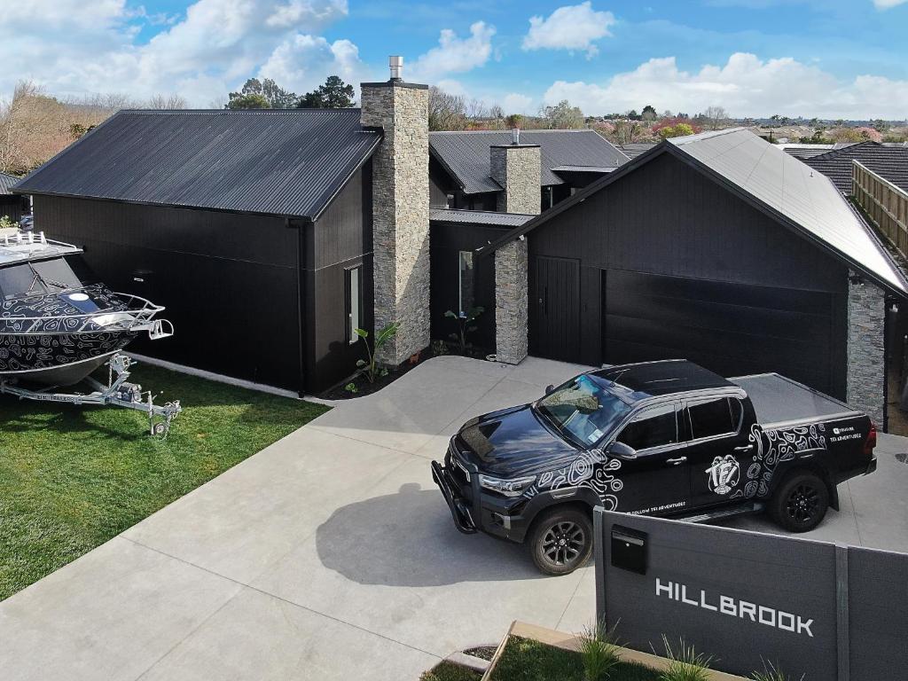 Hillbrook - a luxurious designer house في Ohauiti: شاحنة متوقفة أمام مرآب أسود
