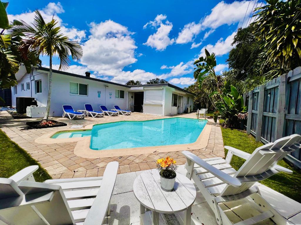 a backyard with a pool and chairs and a house at Outdoor Paradise in Fort Lauderdale