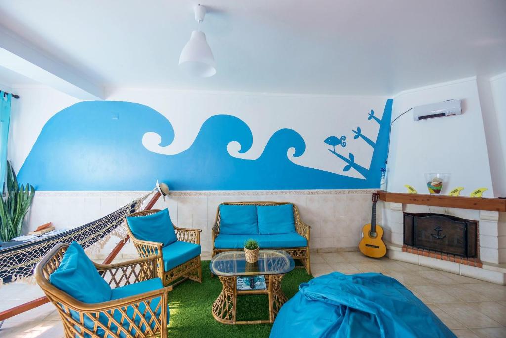 sala de estar con sillas azules y chimenea en H2O GuestHouse, en Baleal