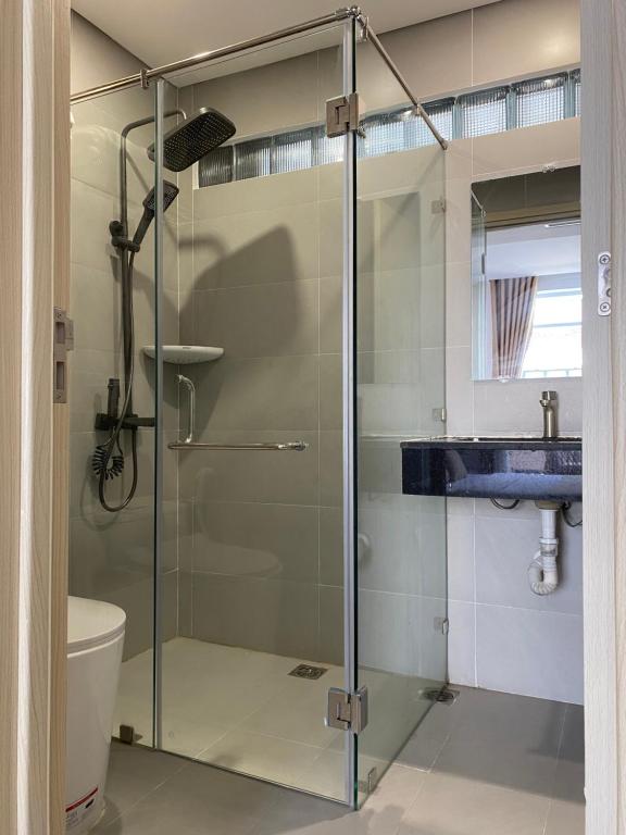 a glass shower stall in a bathroom with a sink at Letters Bà Triệu in Liên Trì (3)