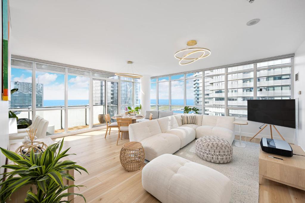 a living room with white furniture and large windows at Lakefront Retreat: Designer Suite w/Stunning Views in Toronto