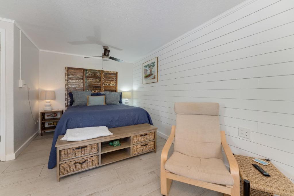 una camera con un letto e una sedia di Tides Inn on the Bay Vacation Homes a Bradenton Beach