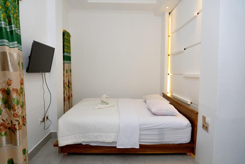 a small bedroom with a bed and a window at Green Prundi Hotel in Labuan Bajo