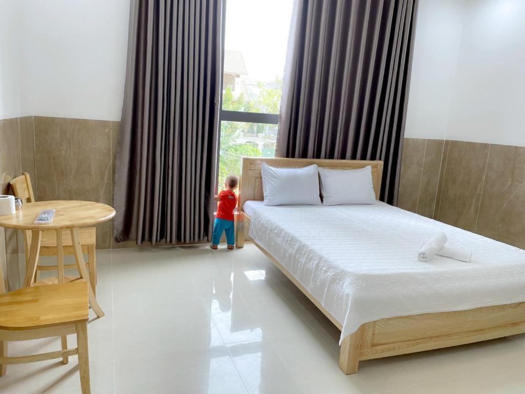 頭頓的住宿－Hotel Hoàng Phúc，卧室里床边的小小孩