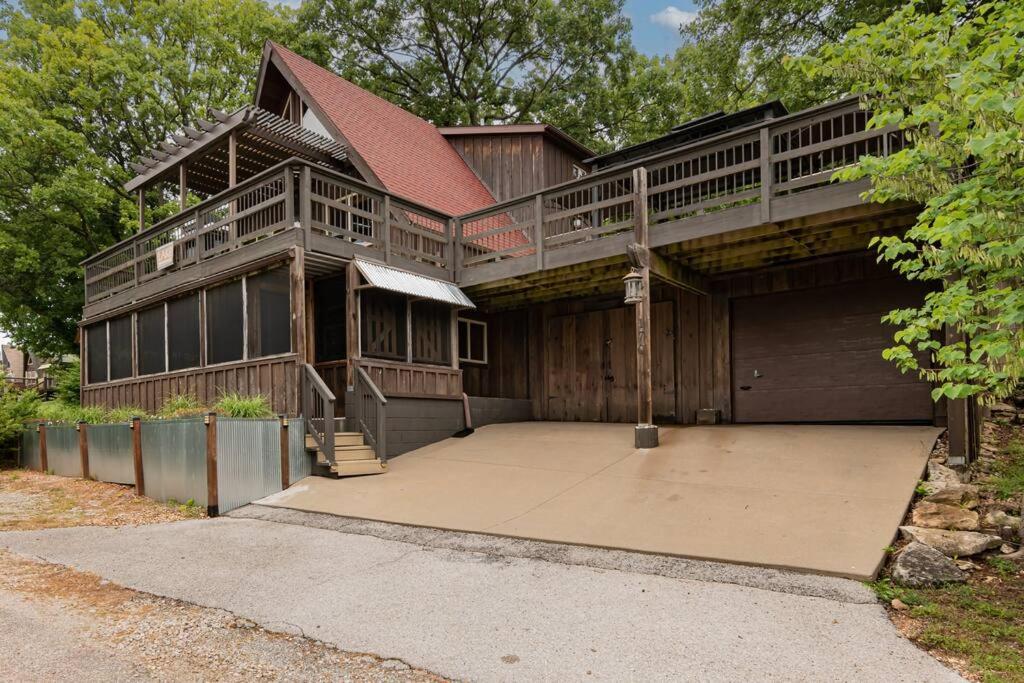 a large wooden house with a porch and a balcony at Charming 4 Bedroom 4 bathroom Lake view home in Lampe
