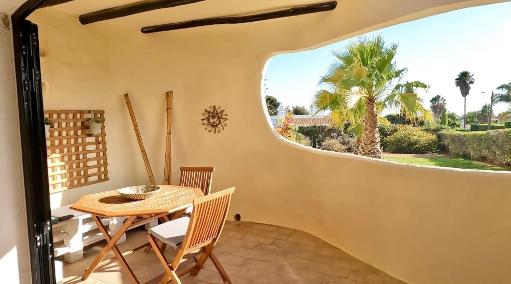 ein Esszimmer mit einem Tisch, Stühlen und einem Fenster in der Unterkunft Casa Flor de Sal Apartment in Carvoeiro