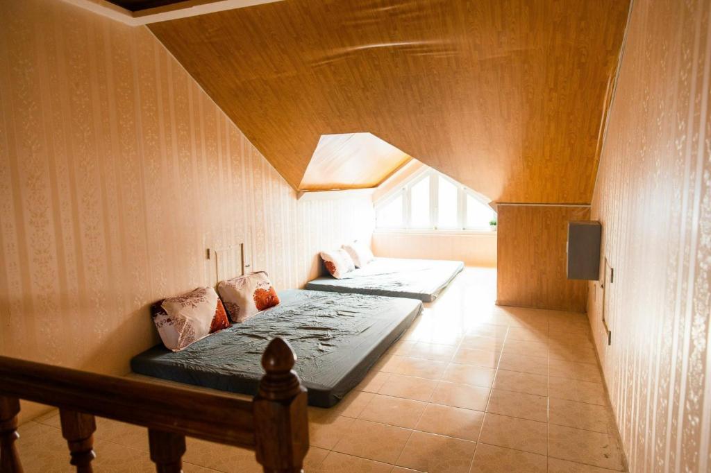 two beds in a room with a wooden ceiling at BACH TUNG Garden Village Đà Lạt in Xuan An