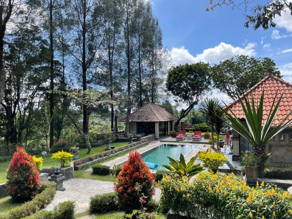 a garden with a swimming pool and a gazebo at Balinese Villa in Berastagi in Berastagi