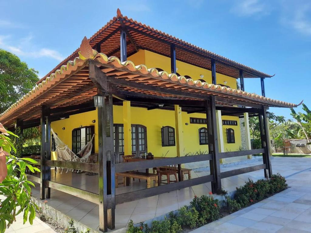een geel huis met een houten dak bij Casa do paiva in Cabo de Santo Agostinho