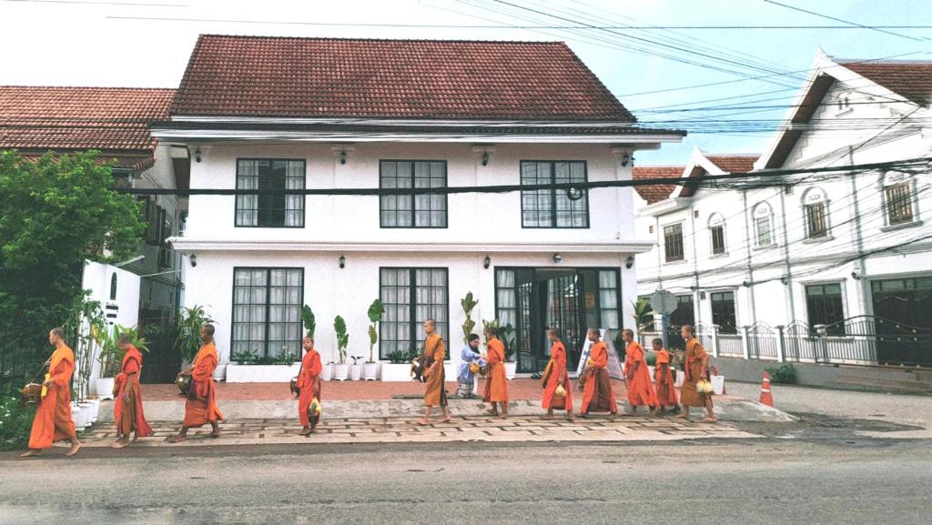 Eine Gruppe von Leuten, die die Straße entlang gehen in der Unterkunft Midnight Blue Guesthouse in Luang Prabang