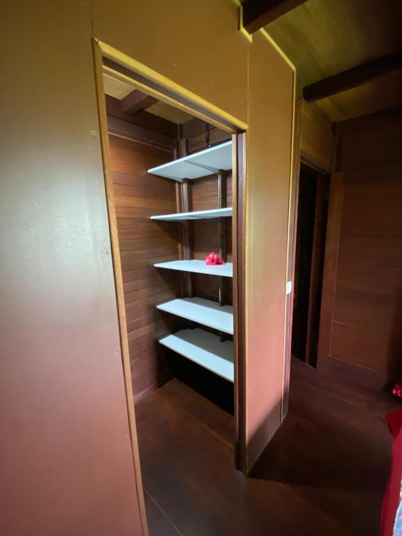 Una habitación con un armario con estanterías. en Chalet Mahina en Mahina