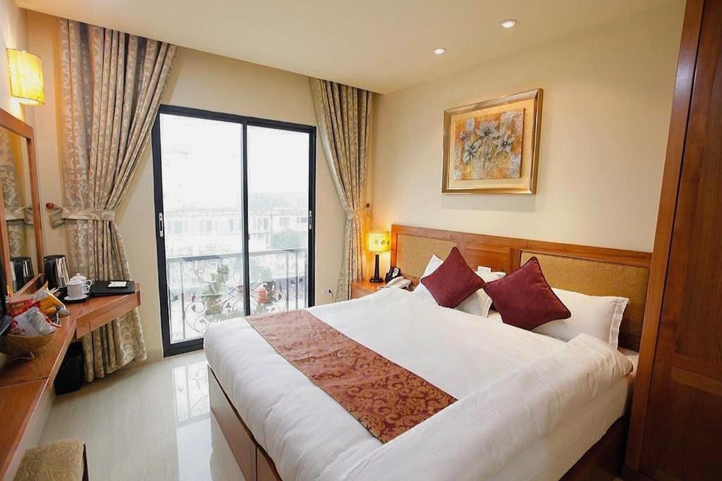 a bedroom with a large bed and a large window at Hanoi B Hotel & Travel - 5 mins Hoan Kiem lake in Hanoi
