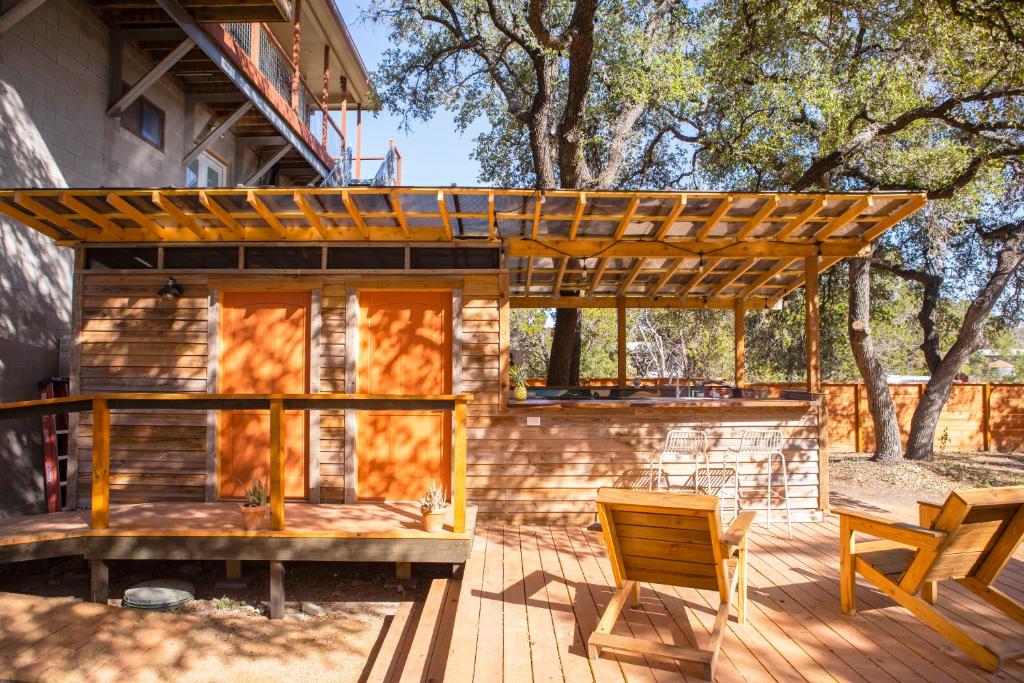 a wooden house with a pergola on a deck at Camposanto Glamping - The Peacock Yurt in Austin