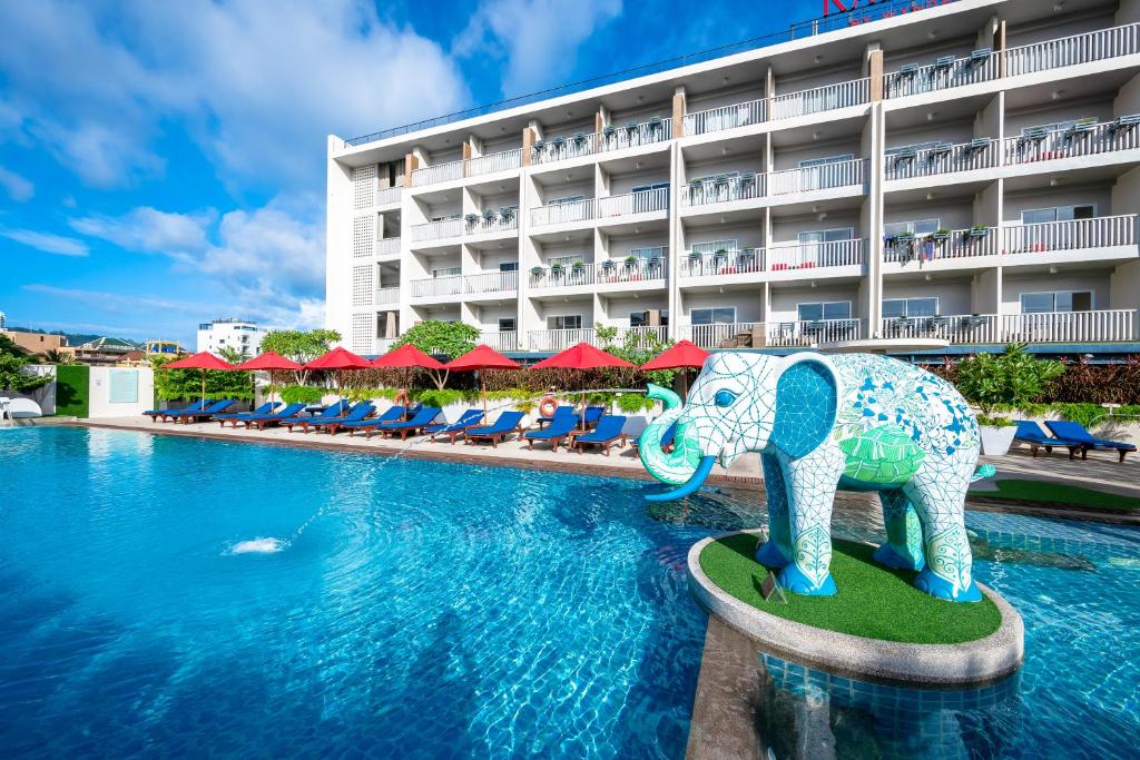 uma piscina com uma estátua de elefante em frente a um hotel em Ramada by Wyndham Phuket Deevana Patong - SHA Extra Plus em Praia de Patong
