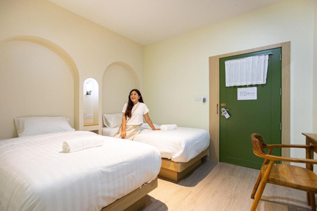 eine Frau in einem Zimmer mit zwei Betten in der Unterkunft PS23 Residence in Hat Yai