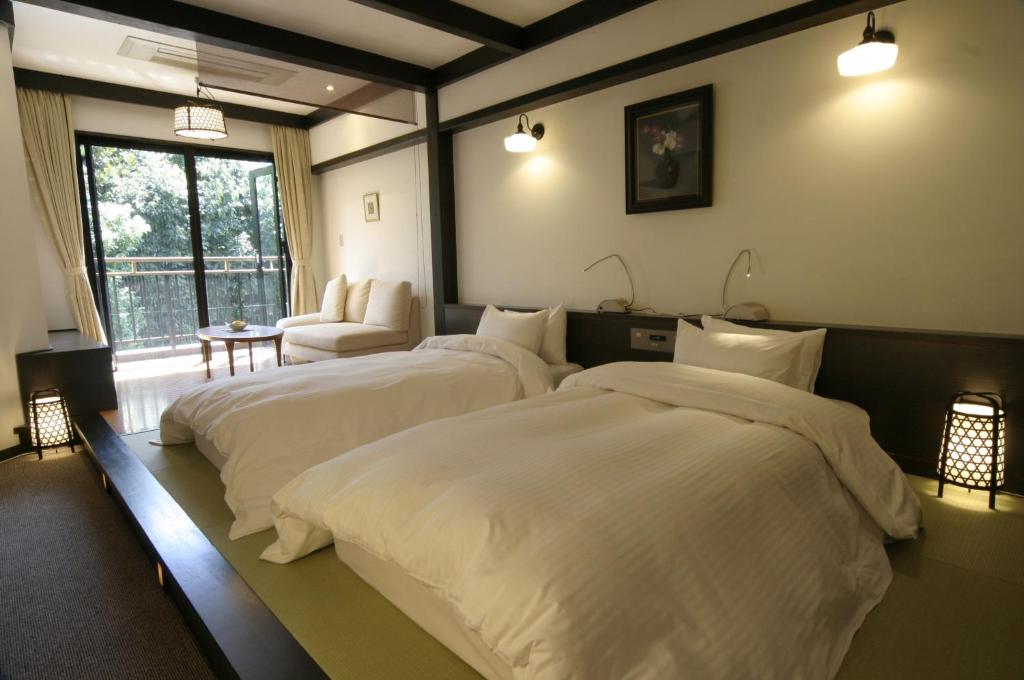 Postel nebo postele na pokoji v ubytování Kasuga Hotel