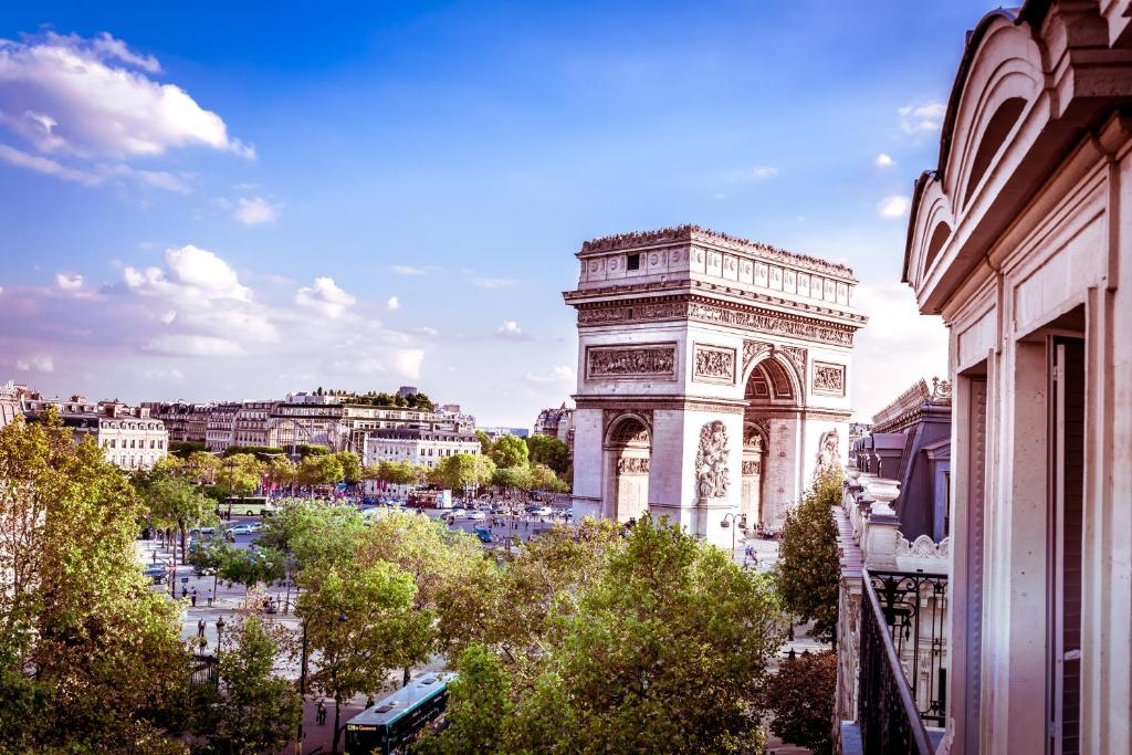 una vista del arco de triunfo y de la torre inclinada en Maison Albar- Le Champs-Elysées en París