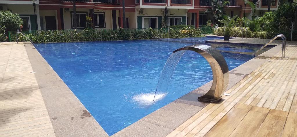 a swimming pool with a water fountain in it at Luxurious Spacious 2 BHK With Pool Wi-Fi Cooking Gas Gym in Calangute