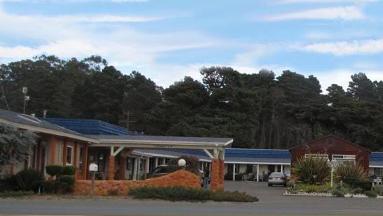 a building with a car parked in a parking lot at Coast Inn and Spa in Fort Bragg