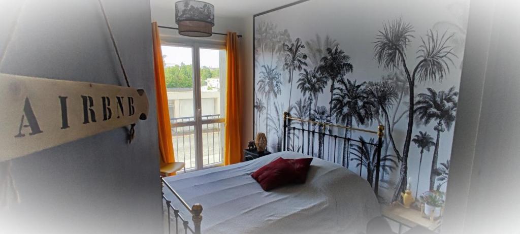Schlafzimmer mit einem Bett und einem Fenster in der Unterkunft Cosy confort appart Cognac in Cognac