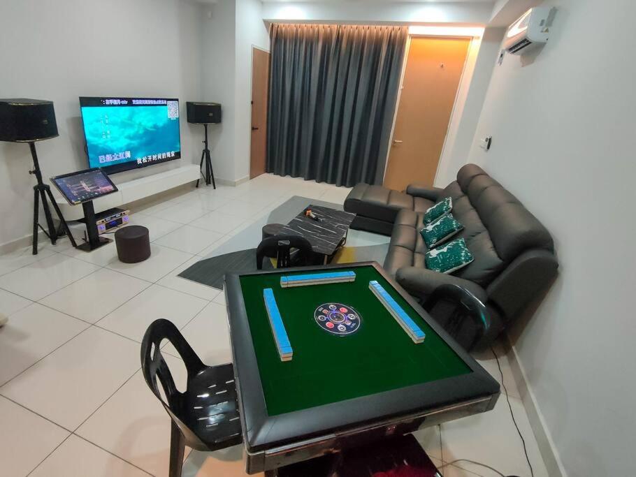 uma sala de estar com uma televisão, um sofá e uma mesa em Happy Home BYSS Homestay em Puchong