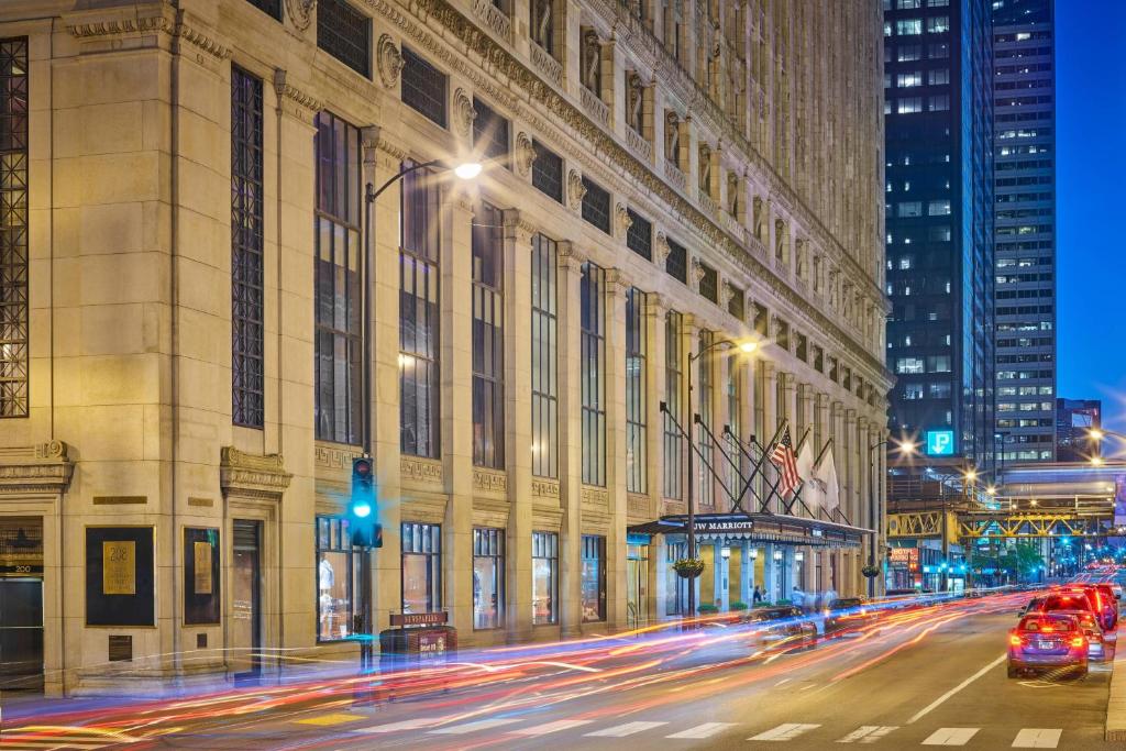 eine Stadtstraße mit Autos, die an einem großen Gebäude vorbeifahren in der Unterkunft JW Marriott Chicago in Chicago