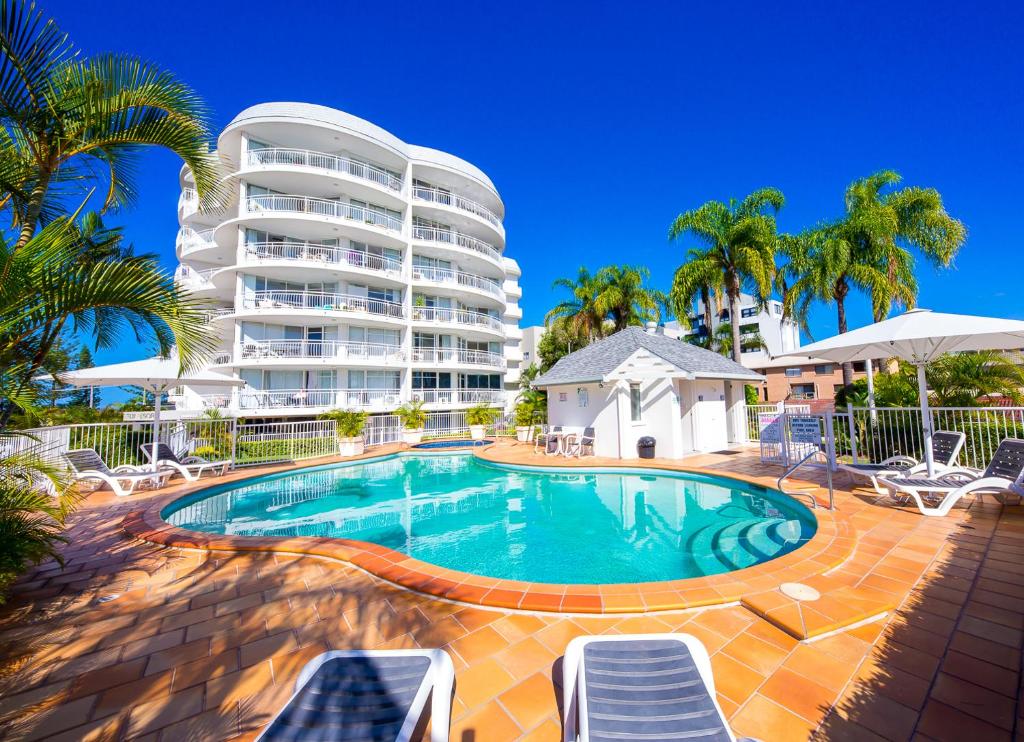 une piscine en face d'un grand immeuble dans l'établissement The Atrium Resort, à Gold Coast