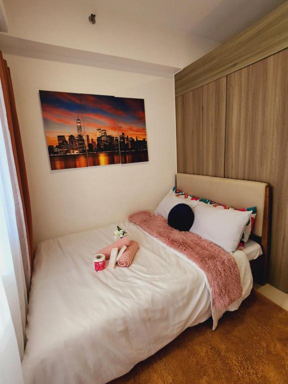 Un dormitorio con una cama con dos muñecas. en Fame Residences Staycation, en Manila