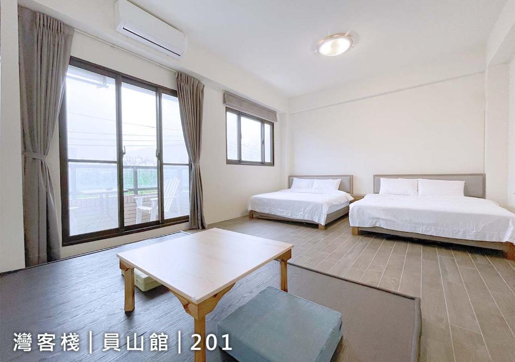 a hotel room with two beds and a table and a window at Yuanshan Dahu Homestay in Yuanshan