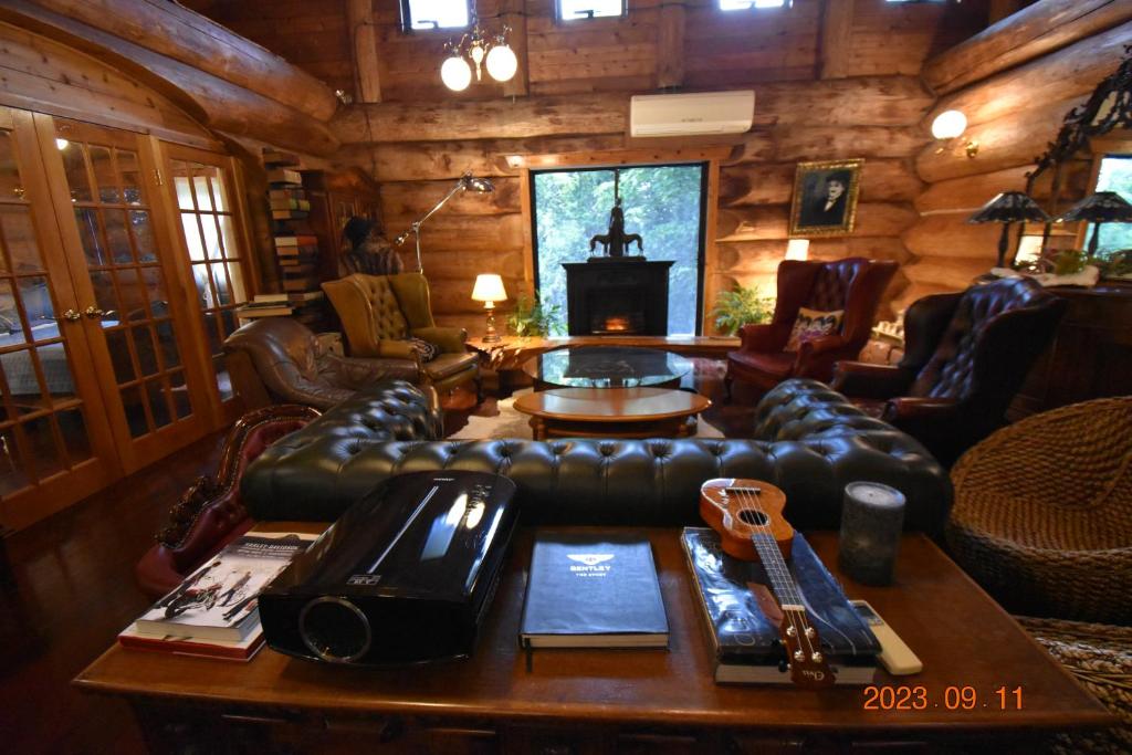 a living room with a leather couch and a table at Pension Prussian Blue in Miyako Island