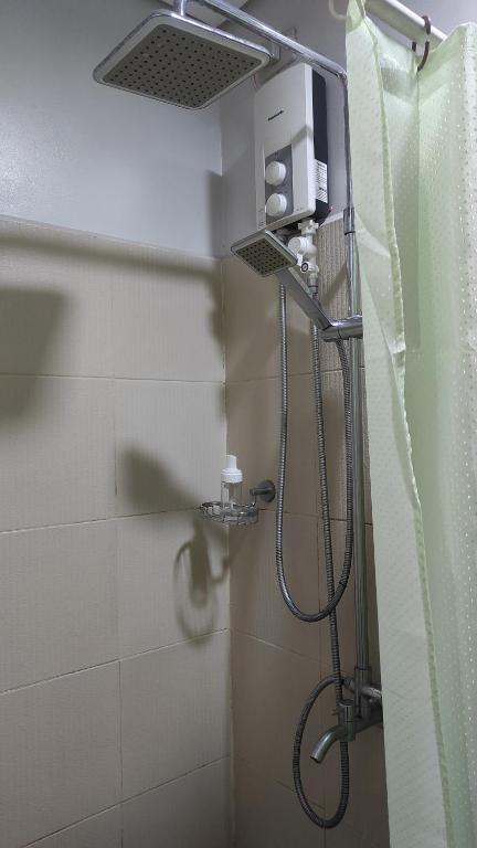 La salle de bains est pourvue d'une douche avec un pommeau de douche. dans l'établissement City View 19th floor Fern at Grass Residences, à Manille