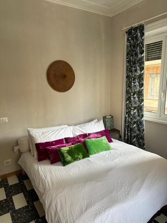 una camera da letto con un letto con cuscini verdi e viola di Room Pilar a Roma