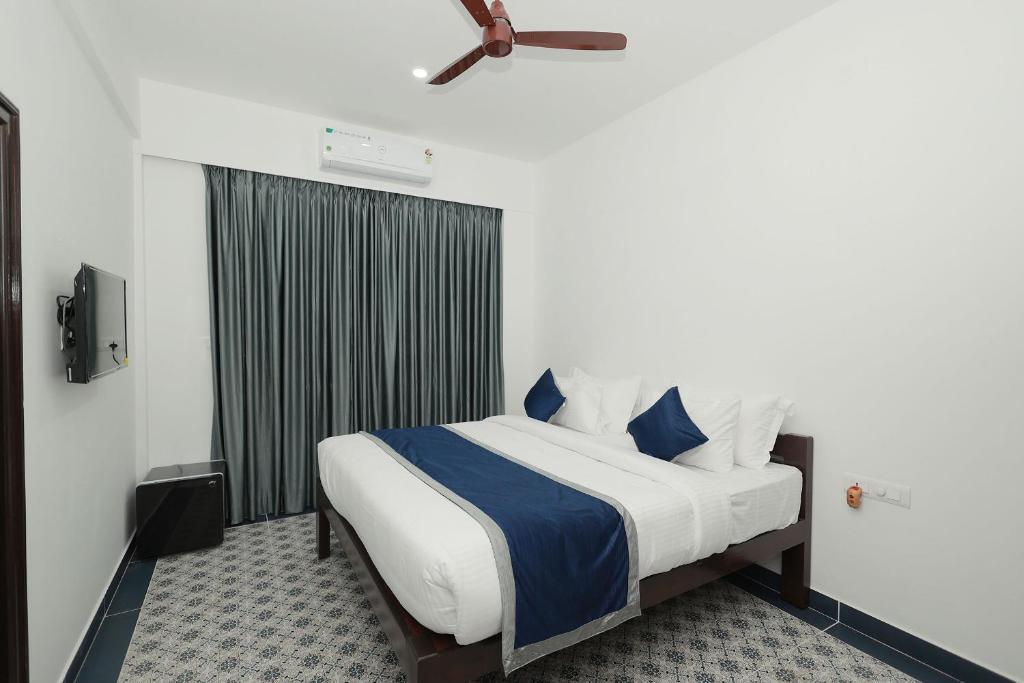 a bedroom with a bed with blue and white sheets at Felix Inn - Manyata Tech Park in Bangalore